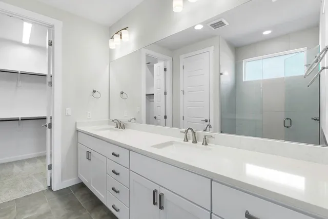 a bathroom with double sink and a mirror