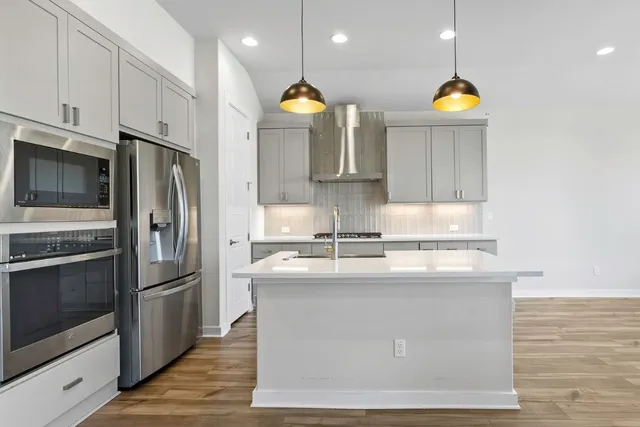 a kitchen with stainless steel appliances granite countertop a sink a stove and a refrigerator