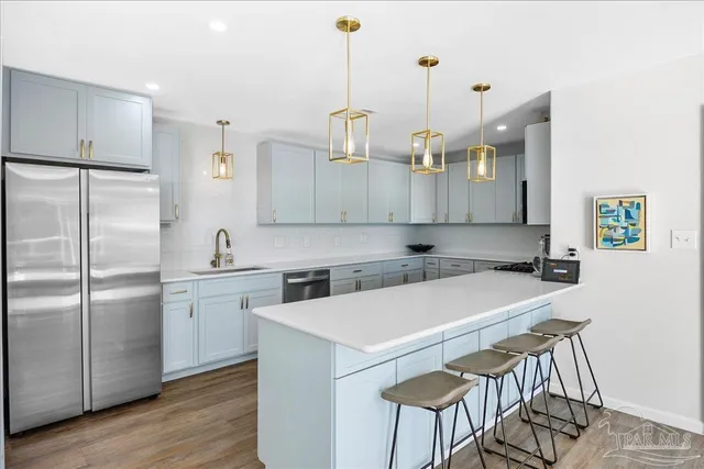a kitchen with a sink a counter top space and stainless steel appliances