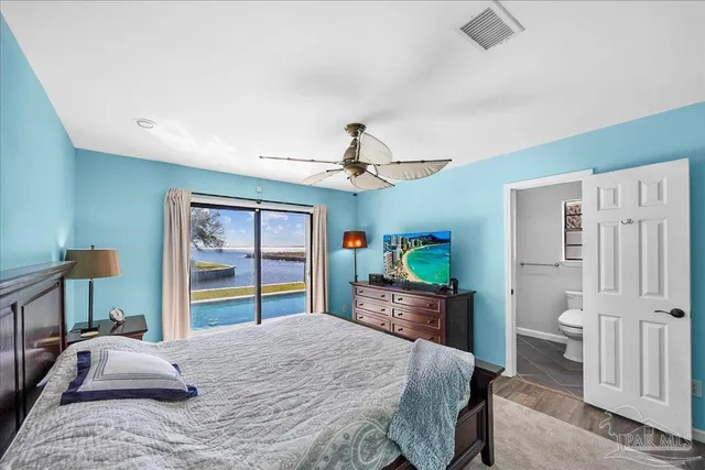 a bedroom with a bed dresser and a large window