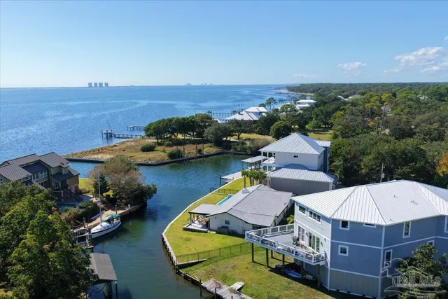 an aerial view of a house with a garden and lake view
