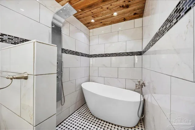 a bathroom with a white bathtub and shower
