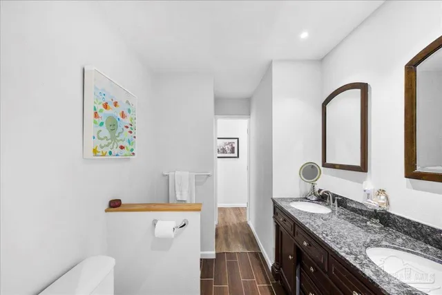 a bathroom with a granite countertop sink a toilet and a mirror