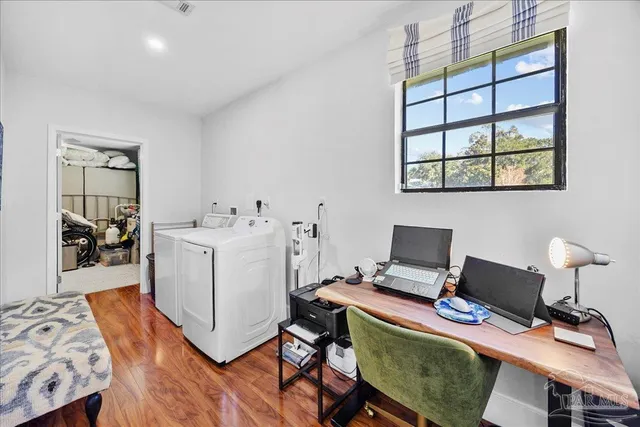 a view of a workspace with furniture and wooden floor