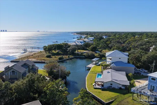 an aerial view of a house with yard and ocean view