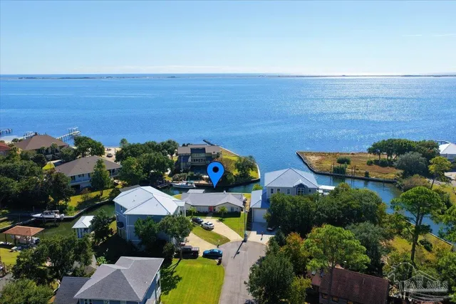 an aerial view of ocean and residential houses with outdoor space