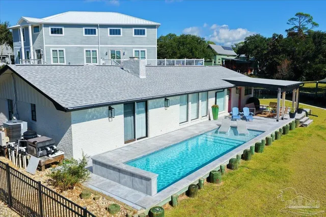 a view of a house with pool and chairs