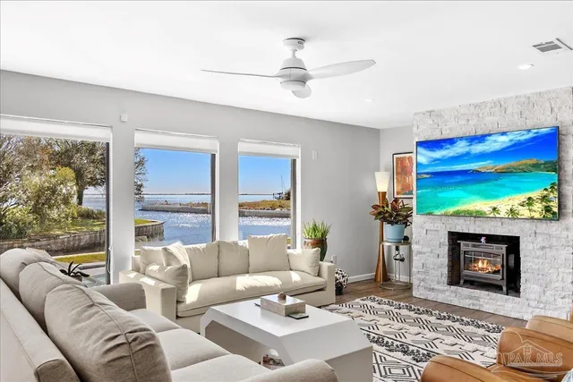 a living room with furniture a large window and a fireplace