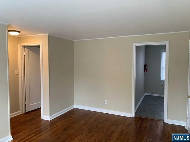 an empty room with wooden floor & closet area