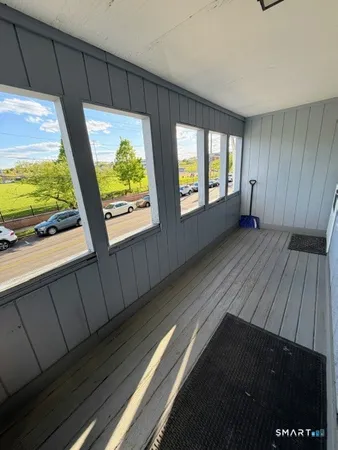 a view of an empty room with wooden floor and windows