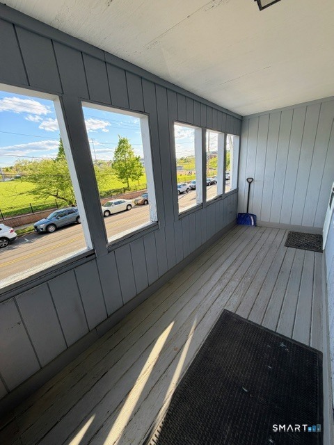 a view of an empty room with wooden floor and windows