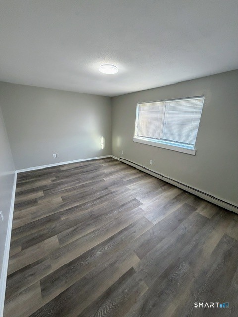 351 Mill Rock Road, Unit 351 Hamden, CT 06517 - Photo 6 of 13 an empty room with wooden floor and windows