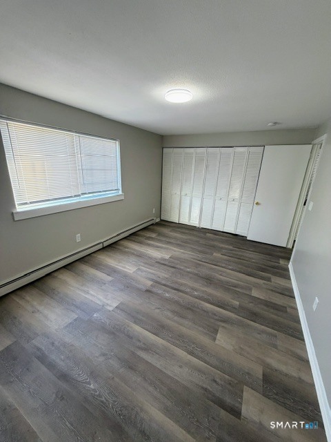 351 Mill Rock Road, Unit 351 Hamden, CT 06517 - Photo 7 of 13 an empty room with wooden floor and windows