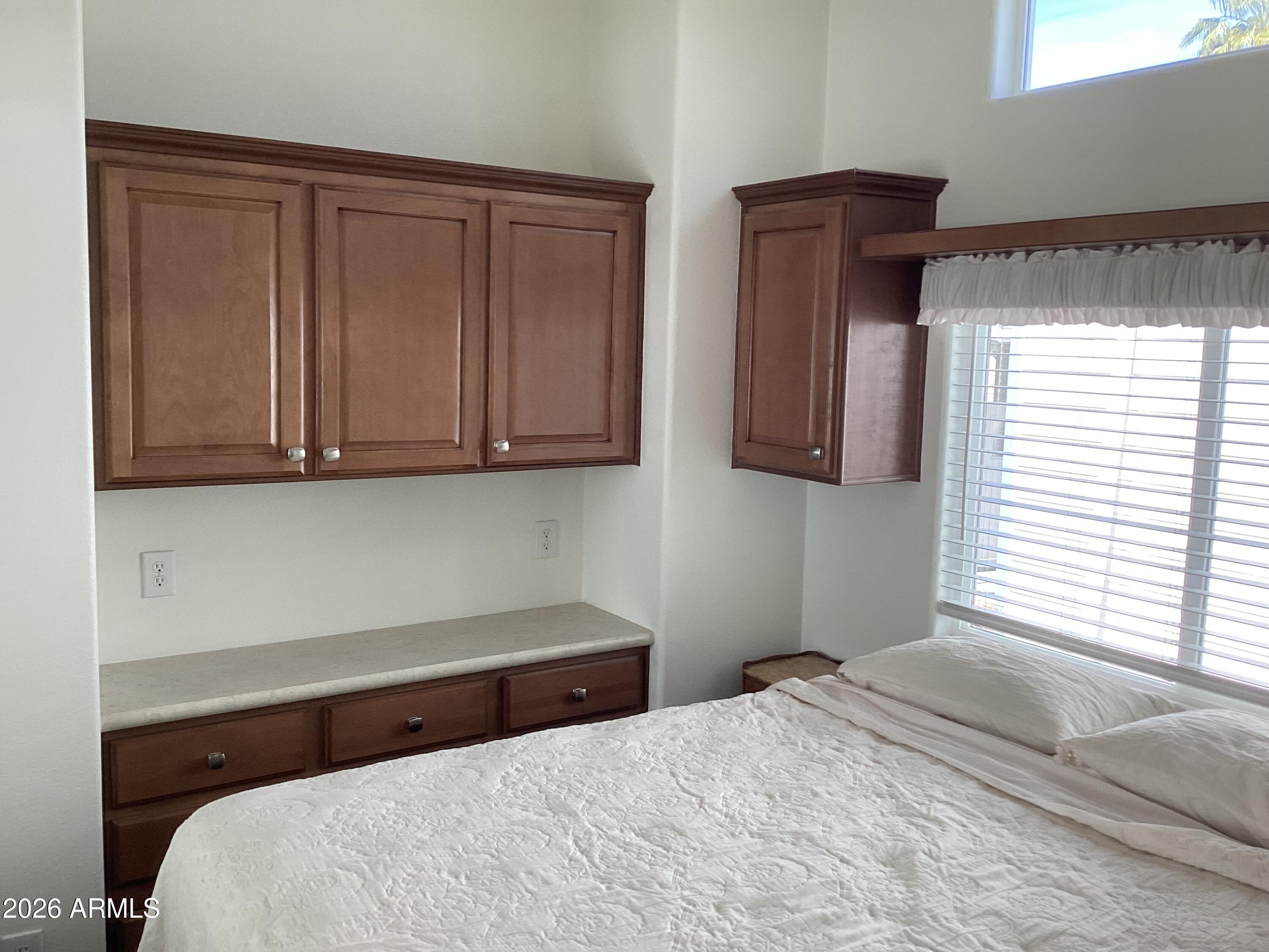 111 South Greenfield Road, Unit 163 Mesa, AZ 85206 - Photo 9 of 16 a bedroom with a bed and cabinets