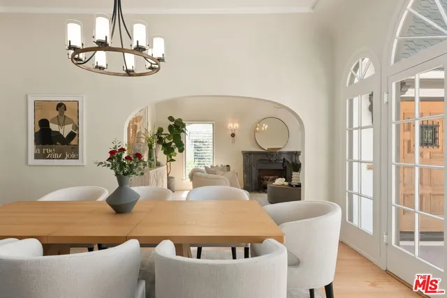 a large dining space with furniture a chandelier and wooden floor