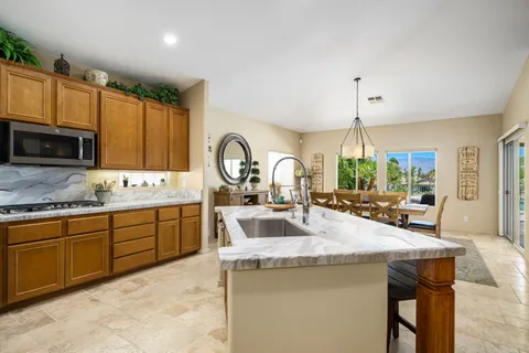 a kitchen with sink a center island and stainless steel appliances