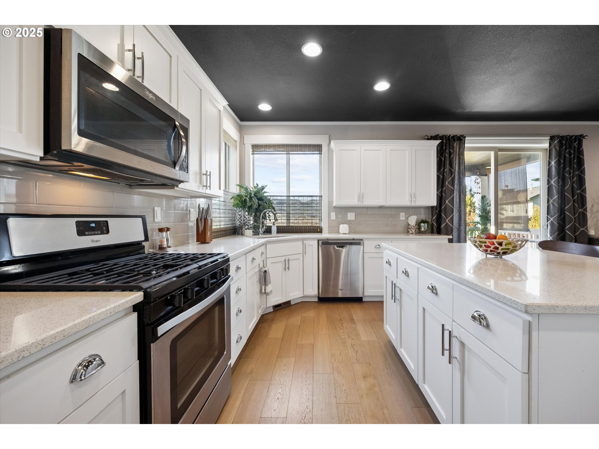 2440 Heather Way Forest Grove, OR 97116 - Photo 9 of 24 a kitchen with stainless steel appliances kitchen island granite countertop a stove a sink and a microwave