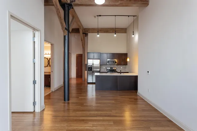 a large kitchen with a lot of counter space and wooden floor