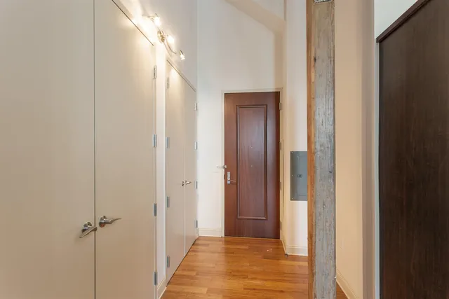 a view of a hallway with a door and wooden floor