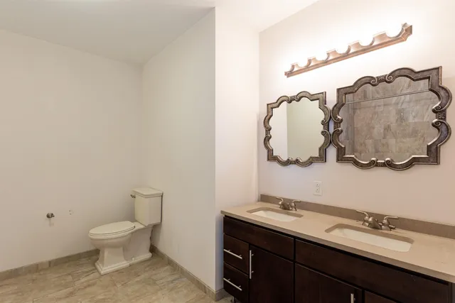 a bathroom with a toilet sink and mirror