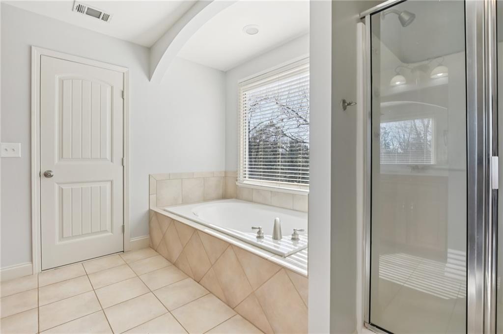 102 Oak Ridge Trail White, GA 30184 - Photo 18 of 31 a bathroom with a tub a mirror and a shower