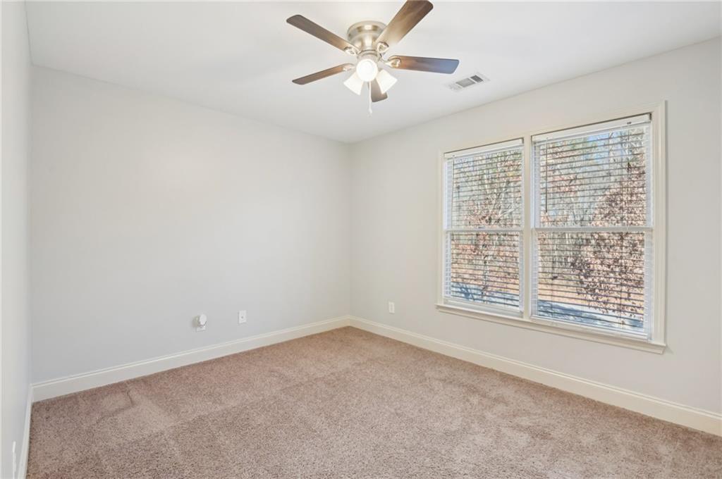 102 Oak Ridge Trail White, GA 30184 - Photo 19 of 31 a view of an empty room with a window and a ceiling fan