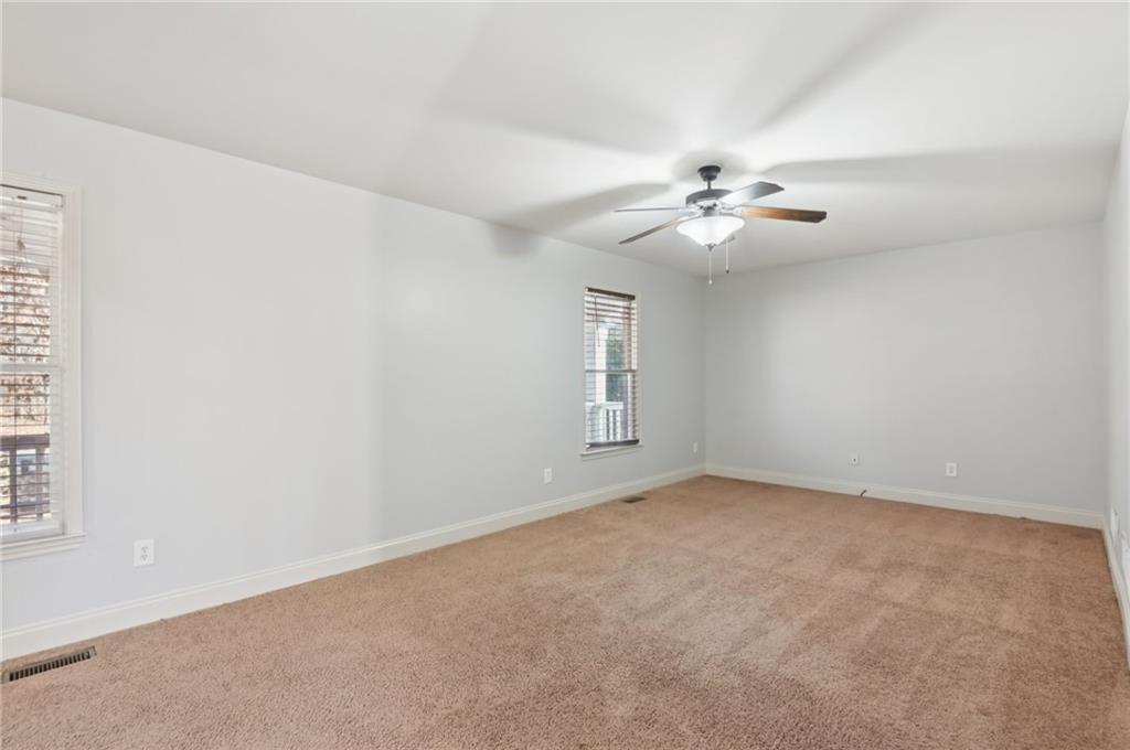 102 Oak Ridge Trail White, GA 30184 - Photo 26 of 31 an empty room with windows and chandelier fan