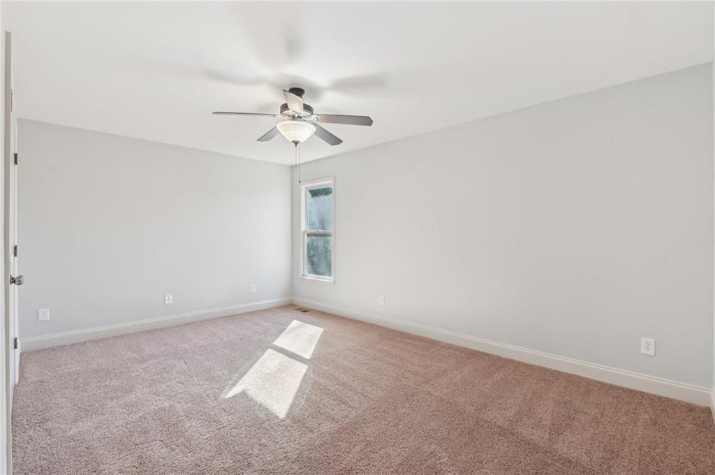 102 Oak Ridge Trail White, GA 30184 - Photo 27 of 31 an empty room with windows and fan