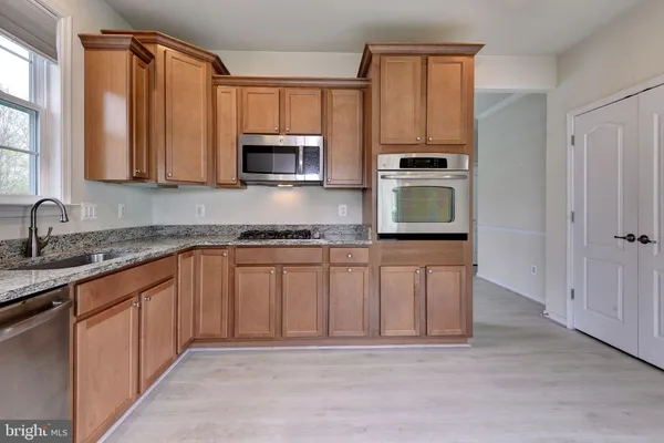 a kitchen with stainless steel appliances granite countertop a stove microwave and sink