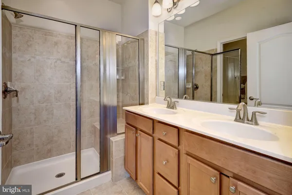 a bathroom with a double vanity sink mirror and shower