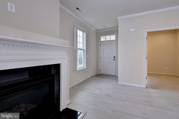 wooden floor fireplace and windows in an empty room