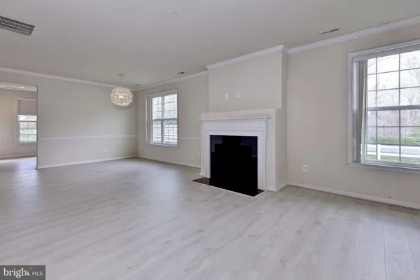 an empty room with windows and fireplace
