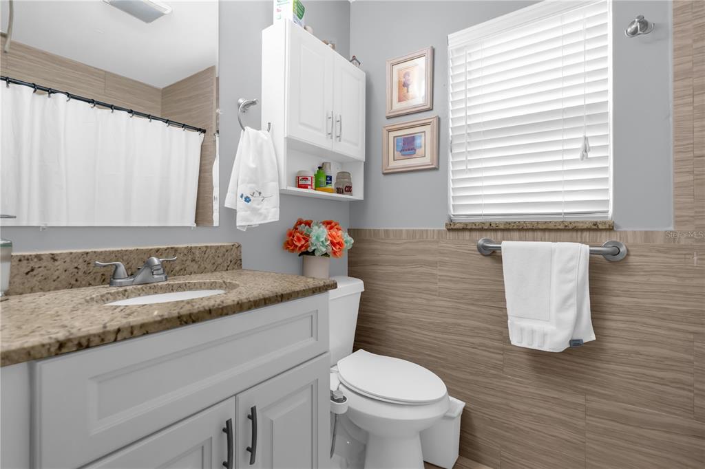 7702 Legacy Lane Orlando, FL 32818 - Photo 17 of 21 a bathroom with a granite countertop sink and a toilet