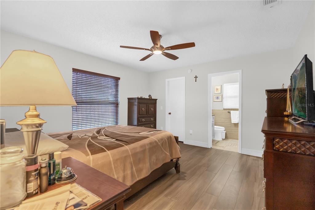 7702 Legacy Lane Orlando, FL 32818 - Photo 5 of 21 a bedroom with a bed and flat screen tv