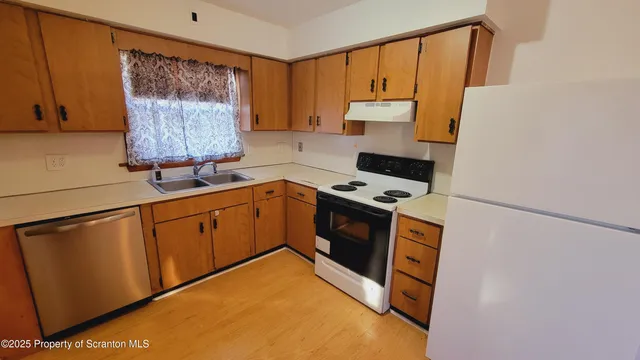 a kitchen with stainless steel appliances a stove a microwave a sink and cabinets