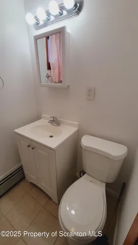 a bathroom with a toilet a sink and mirror
