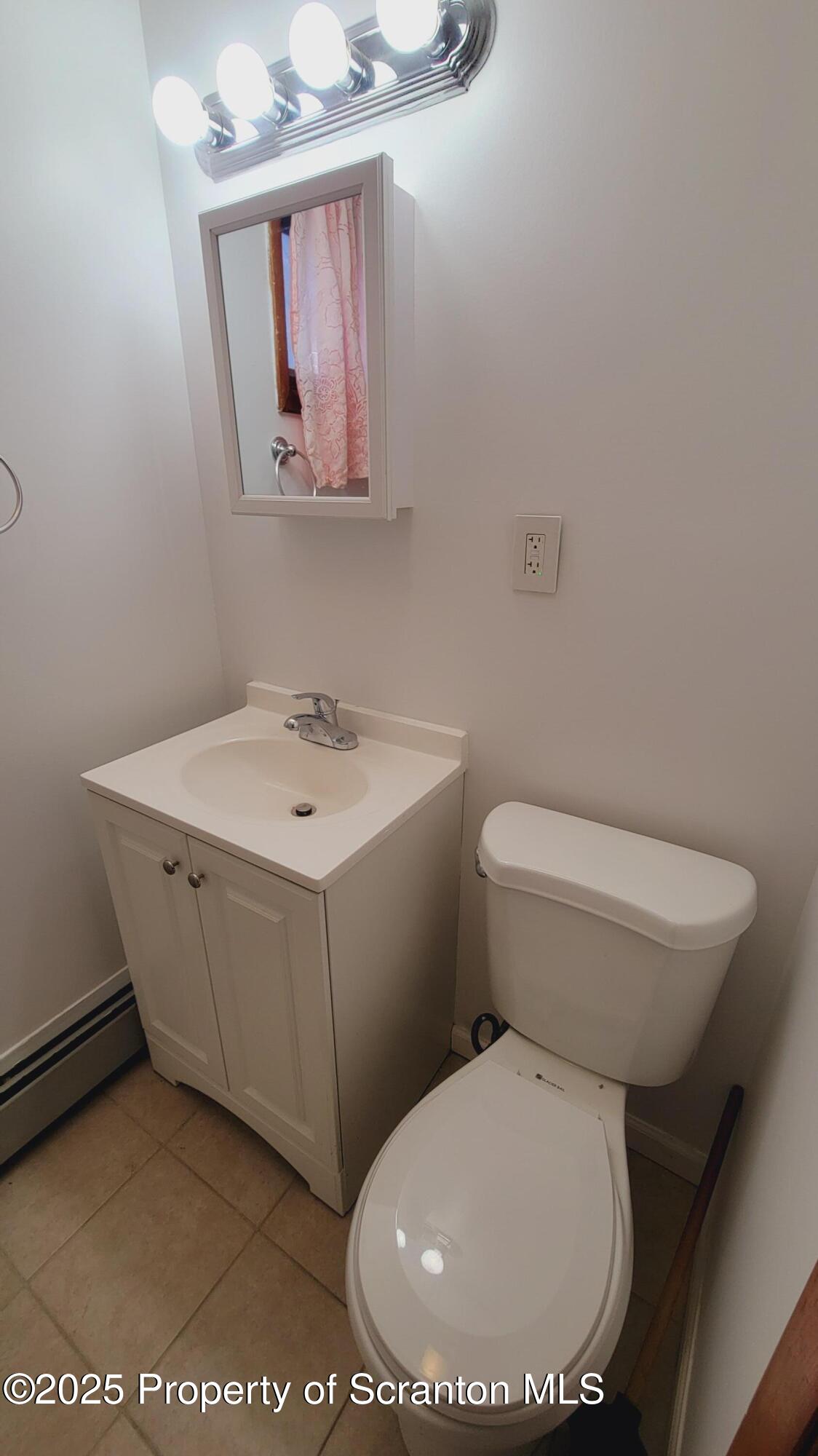 712 Alder Street, Unit FIRST Scranton, PA 18505 - Photo 16 of 18 a bathroom with a toilet a sink and mirror