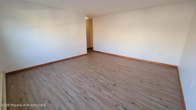 a view of an empty room with wooden floor