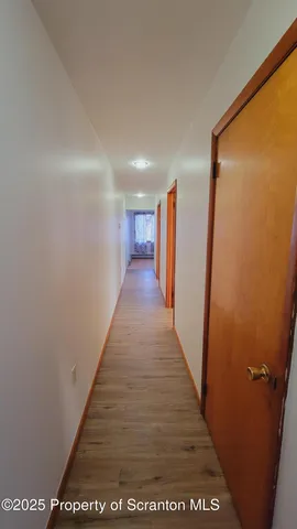 a view of hallway with wooden floor