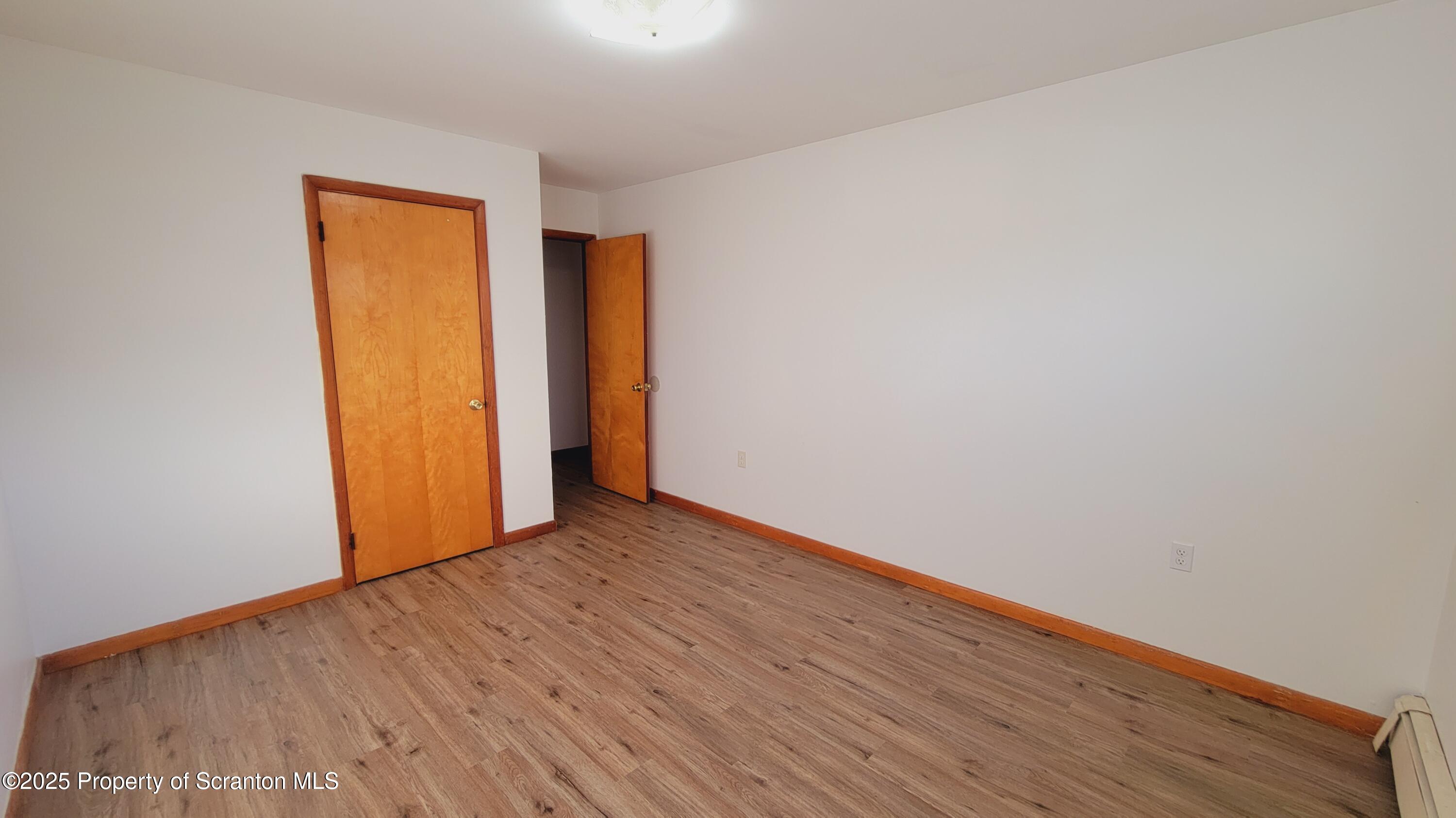 712 Alder Street, Unit FIRST Scranton, PA 18505 - Photo 7 of 18 a view of an empty room with wooden floor and closet