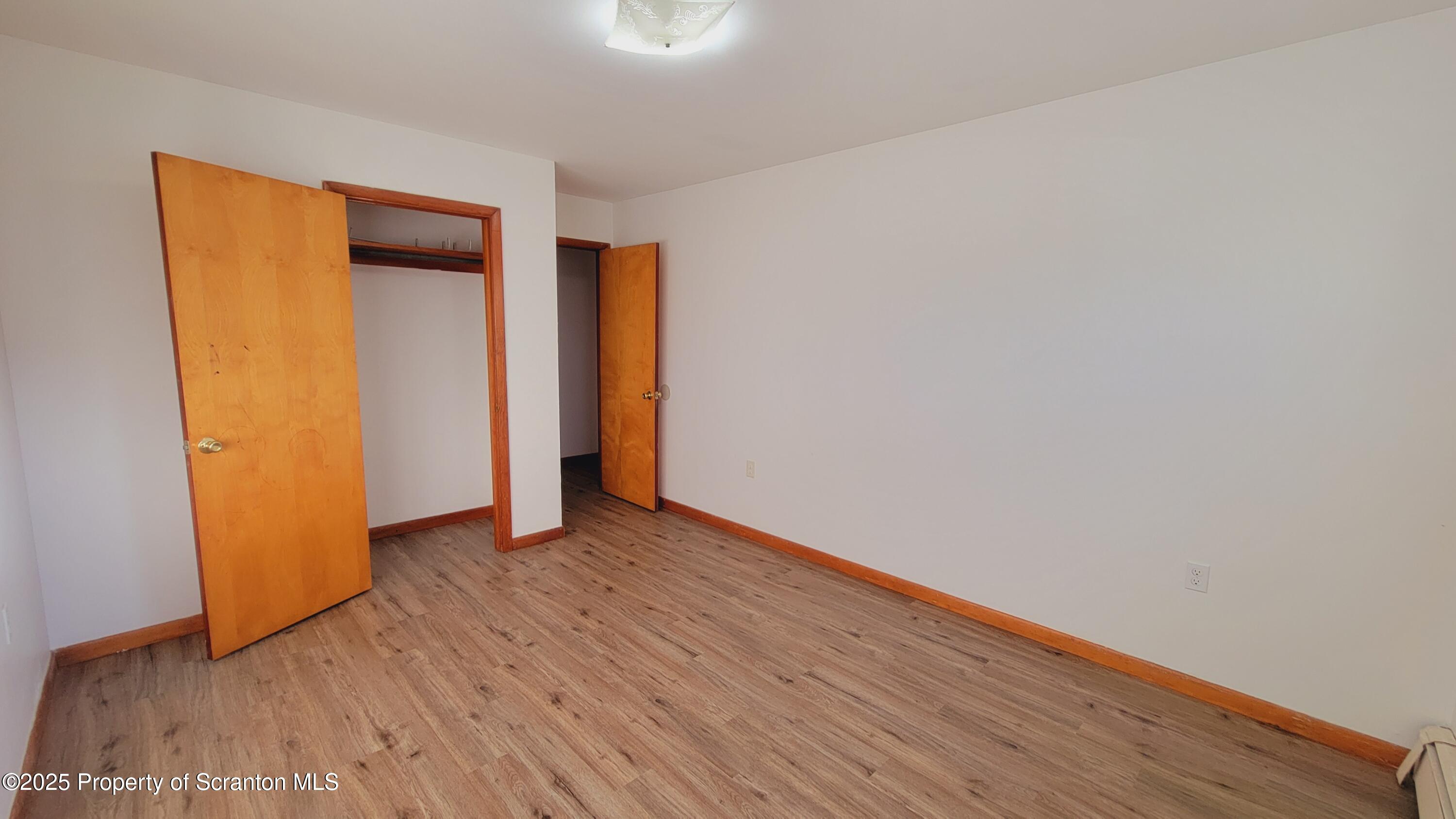 712 Alder Street, Unit FIRST Scranton, PA 18505 - Photo 8 of 18 a view of an empty room with wooden floor and closet