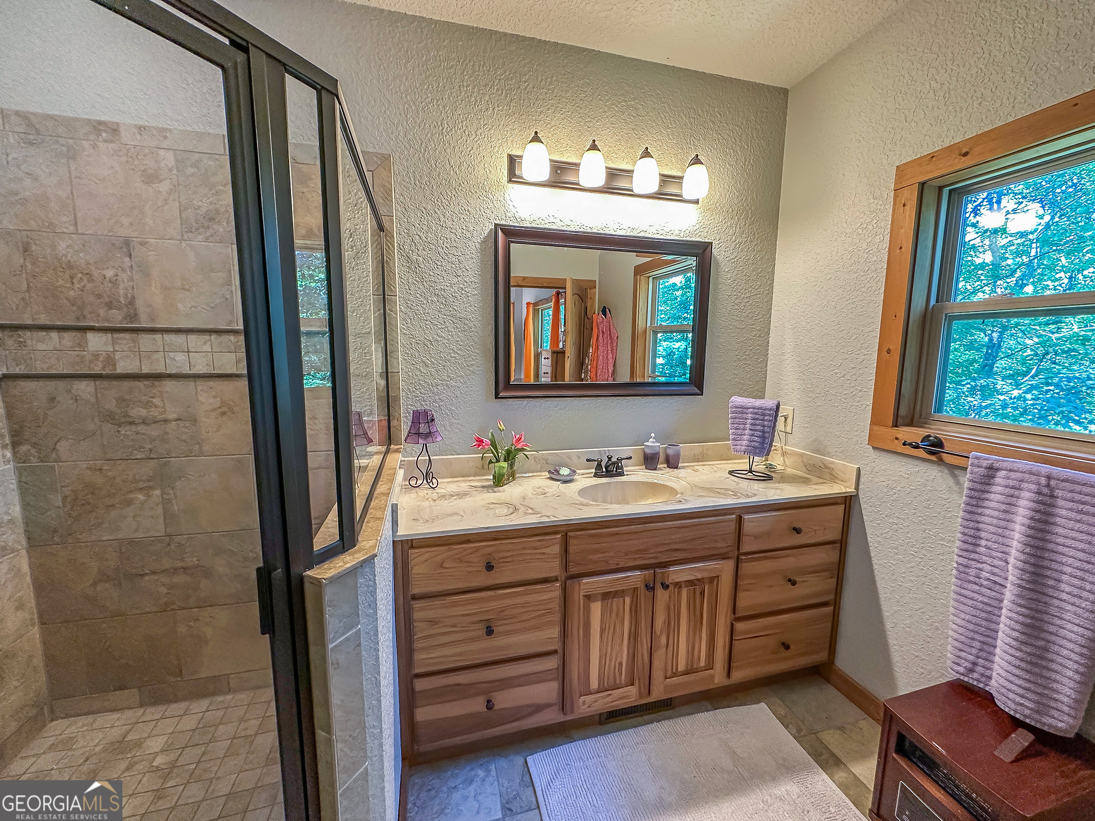 181 Morgan Ridge Court Young Harris, GA 30582 - Photo 17 of 37 a bathroom with a double vanity sink a mirror a window and a bathtub