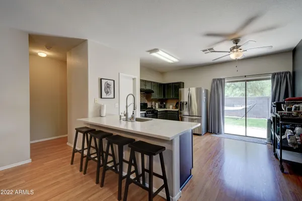 a kitchen with stainless steel appliances granite countertop a kitchen island hardwood floor and a sink