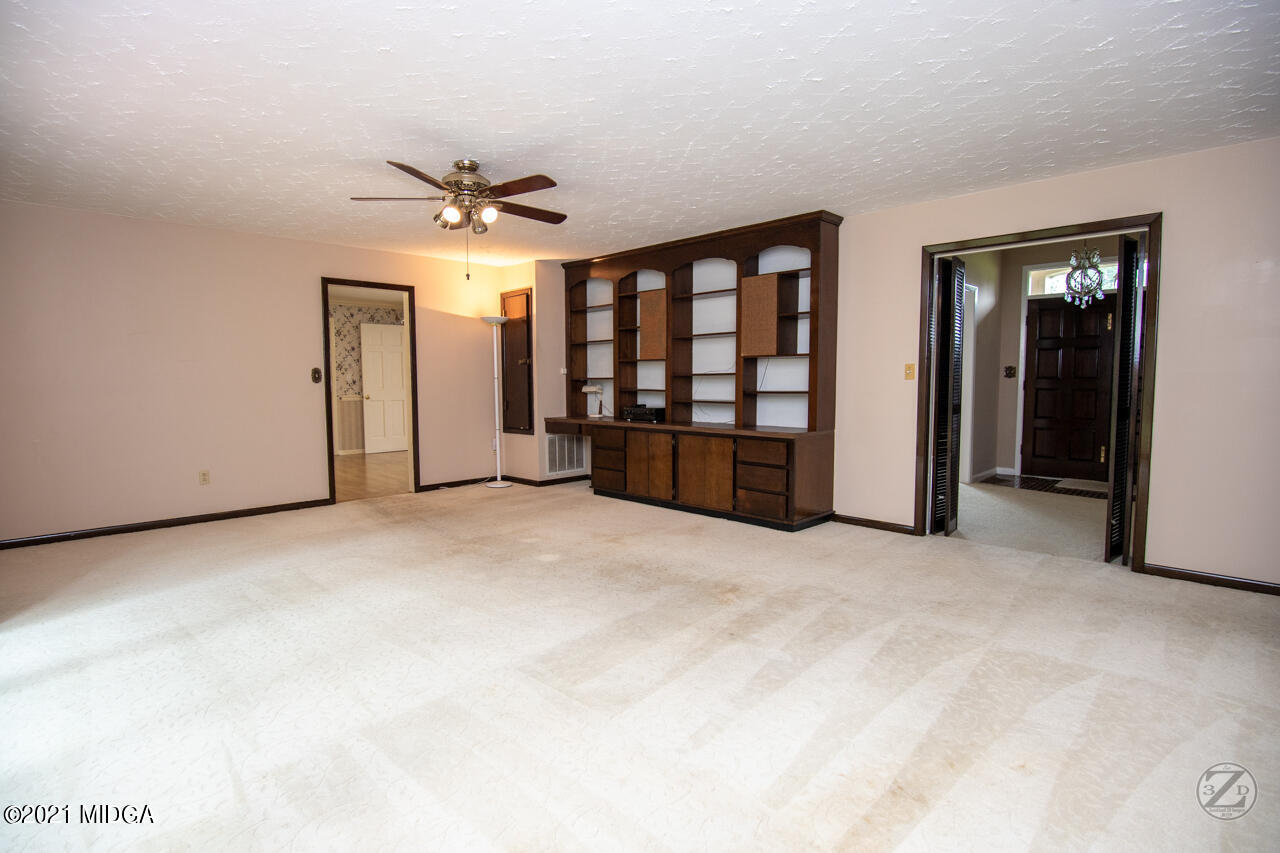1027 Country Club Road Perry, GA 31069 - Photo 11 of 55 an empty room with chandelier fan and windows