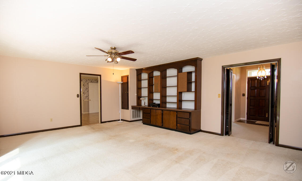 1027 Country Club Road Perry, GA 31069 - Photo 14 of 55 an empty room with windows and ceiling fan