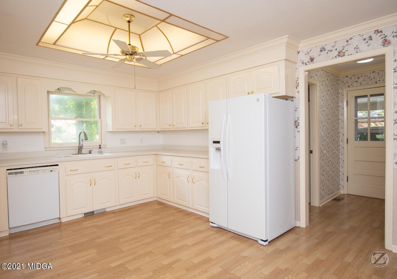 1027 Country Club Road Perry, GA 31069 - Photo 24 of 55 a kitchen with white cabinets and white appliances