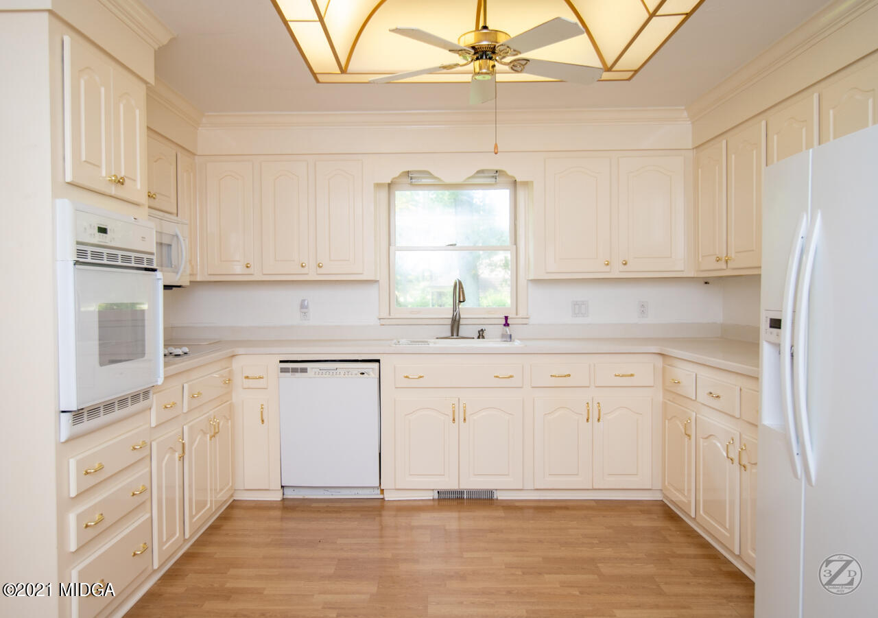 1027 Country Club Road Perry, GA 31069 - Photo 25 of 55 a kitchen with stainless steel appliances white cabinets and a refrigerator