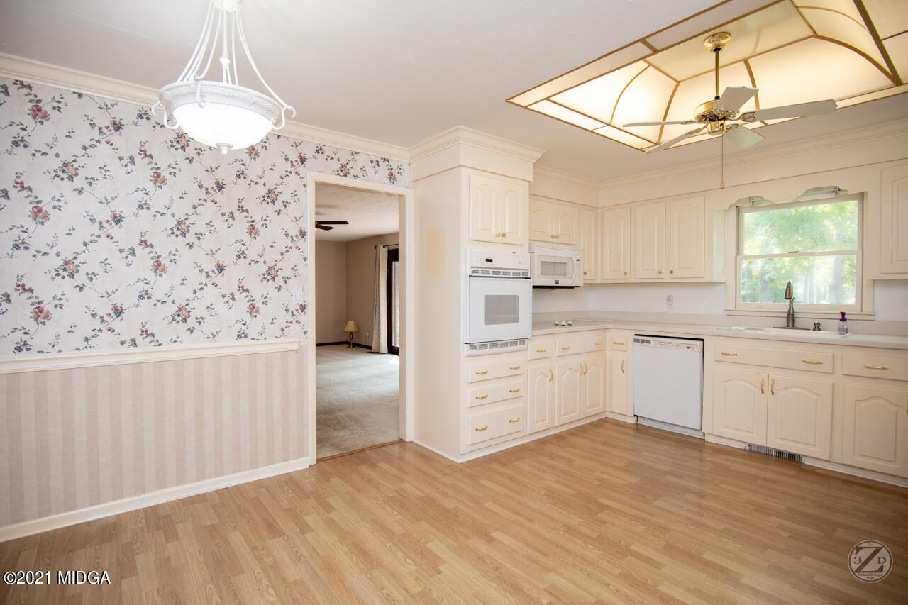 1027 Country Club Road Perry, GA 31069 - Photo 26 of 55 a kitchen with granite countertop white cabinets and white appliances