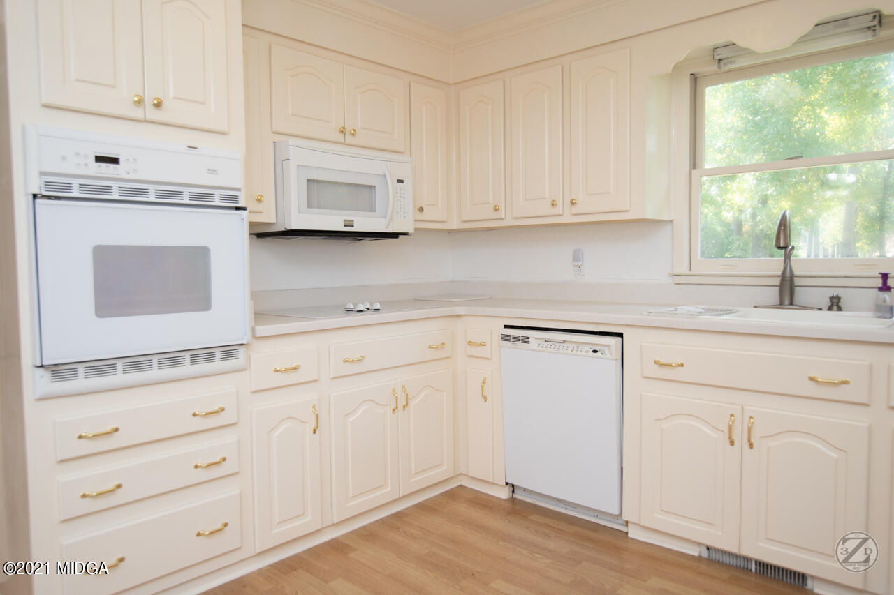 1027 Country Club Road Perry, GA 31069 - Photo 27 of 55 a kitchen with granite countertop white cabinets and white appliances