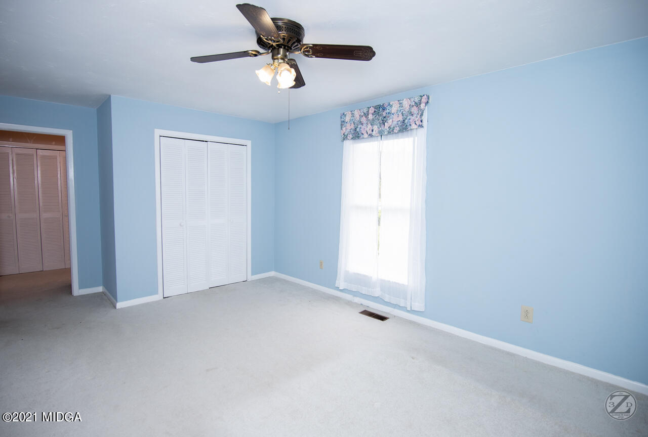 1027 Country Club Road Perry, GA 31069 - Photo 38 of 55 an empty room with a window and a fan